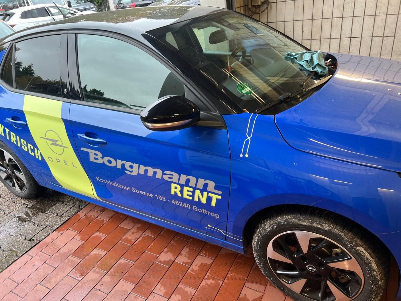 Blauer Opel Corsa mit Werbebeklebung vor der Aufbereitung